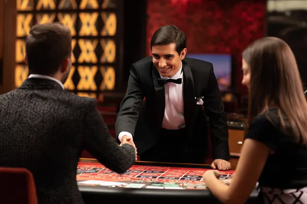 সবুজ বিলাসবহুল গাউন পরা এক নারী অলংকৃত রুলেট চাকার পাশে—যা BK33–এর উচ্চমানের ক্যাসিনো পরিবেশকে প্রকাশ করে।